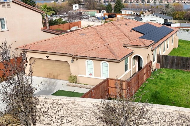 exterior space with a garage, a front lawn, and solar panels