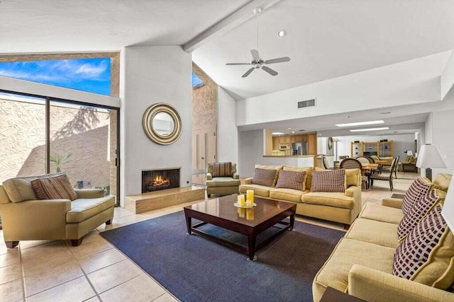 living room with ceiling fan, light tile patterned flooring, beam ceiling, and high vaulted ceiling