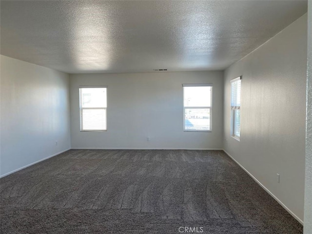 carpeted spare room with a textured ceiling