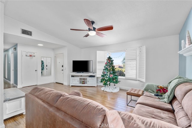 living room featuring light wood-type flooring, vaulted ceiling, and ceiling fan