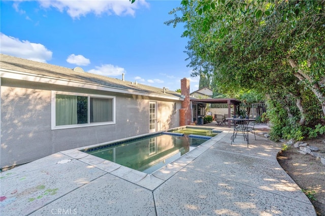 view of pool featuring an in ground hot tub and a patio