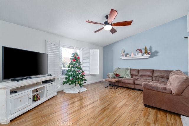 living room with ceiling fan, light wood-type flooring, and vaulted ceiling