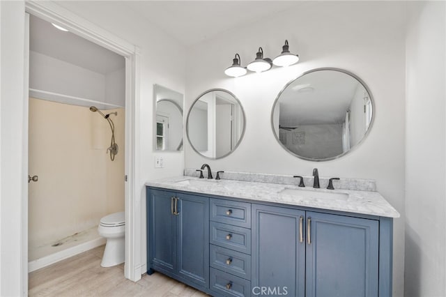 bathroom with toilet, walk in shower, hardwood / wood-style floors, and vanity