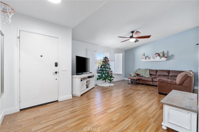 living room featuring ceiling fan, vaulted ceiling, and light hardwood / wood-style flooring