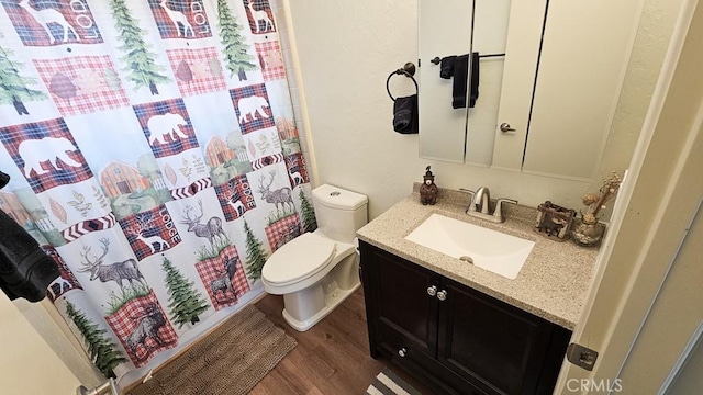 bathroom featuring toilet, vanity, curtained shower, and hardwood / wood-style flooring