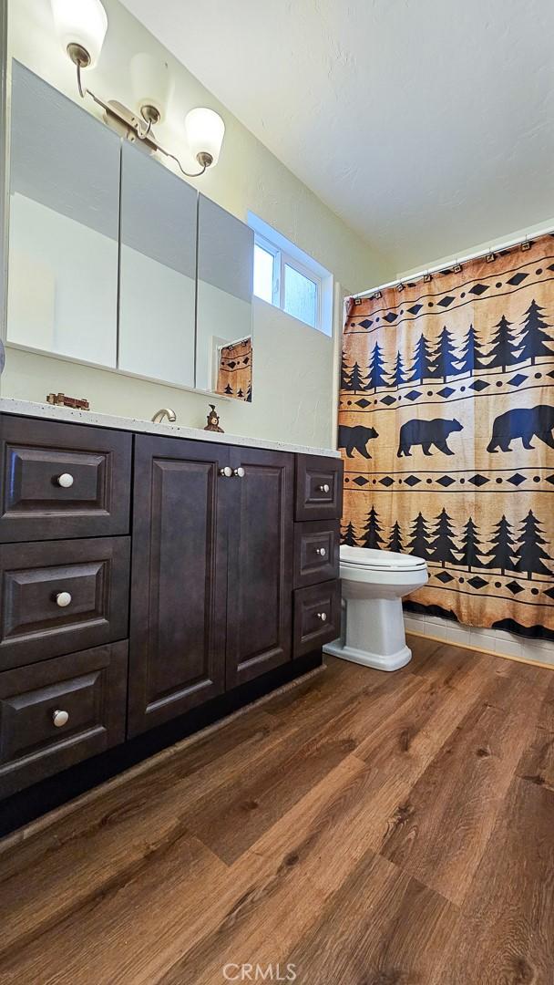 bathroom featuring toilet and wood-type flooring