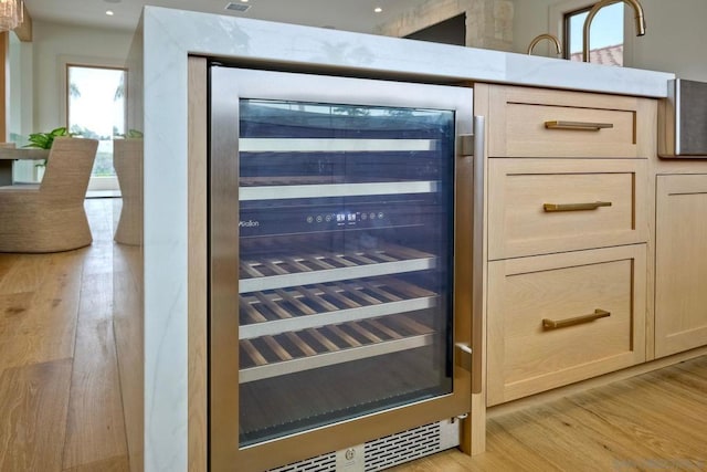 details with wine cooler, light brown cabinetry, and light hardwood / wood-style flooring