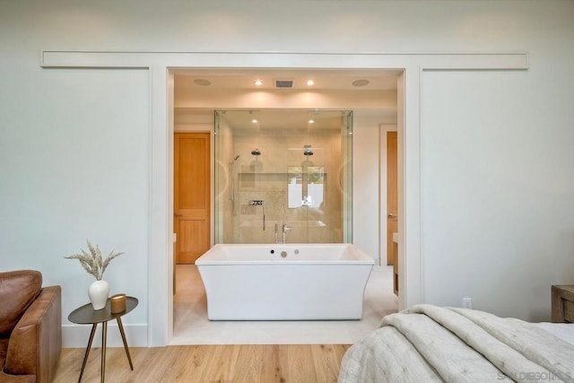 bathroom with hardwood / wood-style flooring and plus walk in shower