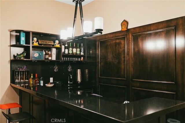 bar with dark brown cabinetry and sink