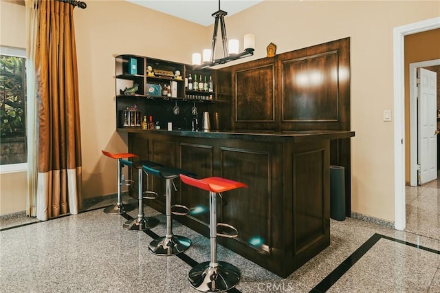 bar featuring pendant lighting and dark brown cabinetry