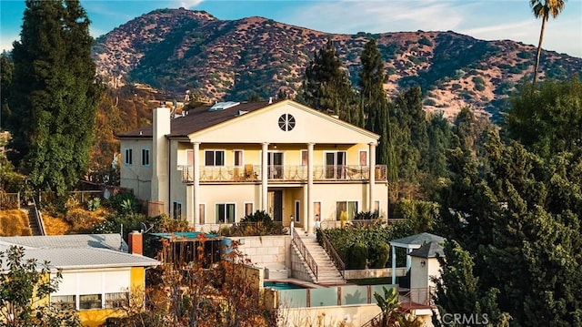 view of front of house featuring a mountain view and a balcony