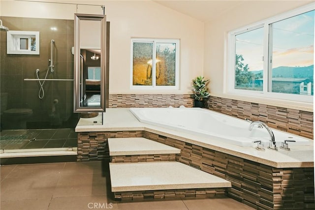 bathroom featuring vaulted ceiling, shower with separate bathtub, and tile patterned flooring