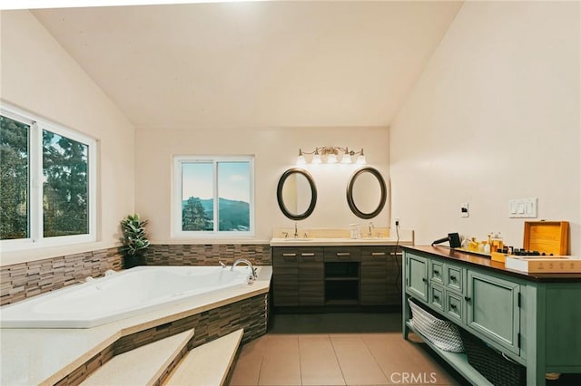 bathroom featuring a bathtub, lofted ceiling, tile patterned floors, and vanity