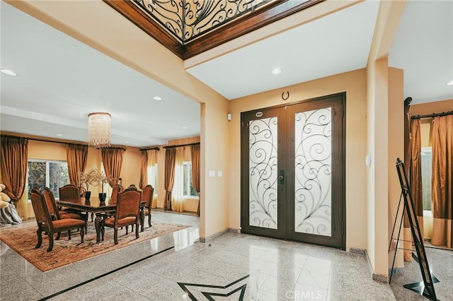 entryway with french doors and a chandelier