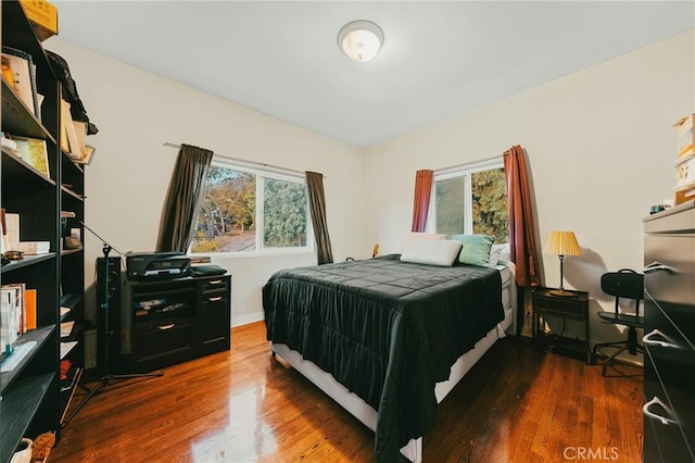 bedroom with dark hardwood / wood-style flooring