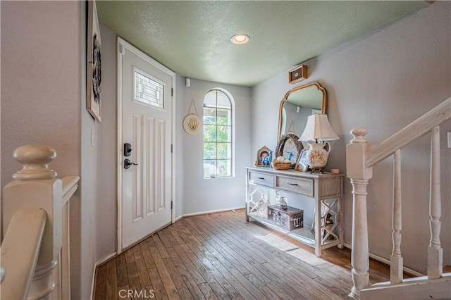 entryway with a textured ceiling and light hardwood / wood-style flooring