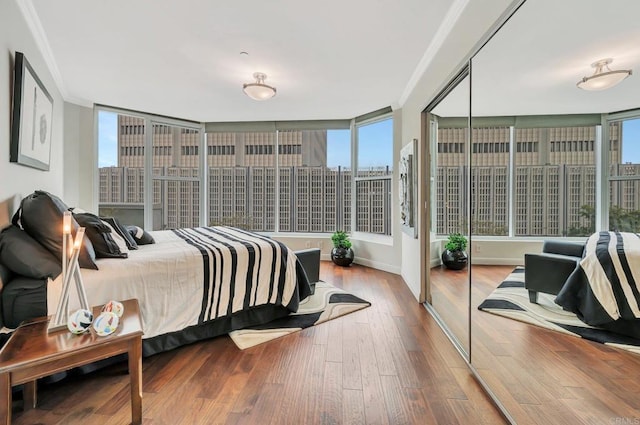 bedroom with hardwood / wood-style floors, a closet, and crown molding