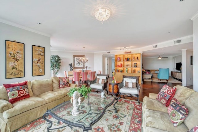 living room featuring ceiling fan with notable chandelier, ornamental molding, and hardwood / wood-style flooring