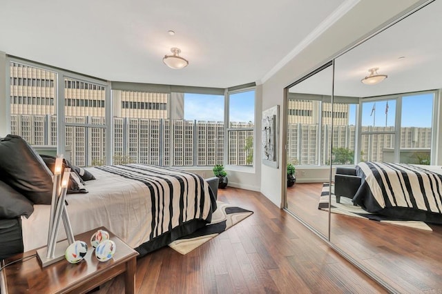 bedroom featuring a closet, ornamental molding, and hardwood / wood-style flooring