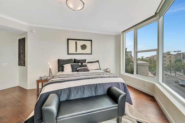 bedroom with dark hardwood / wood-style flooring and crown molding