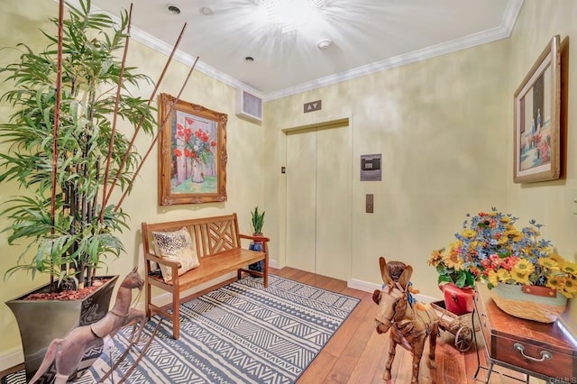 living area featuring a chandelier, crown molding, light hardwood / wood-style flooring, and elevator