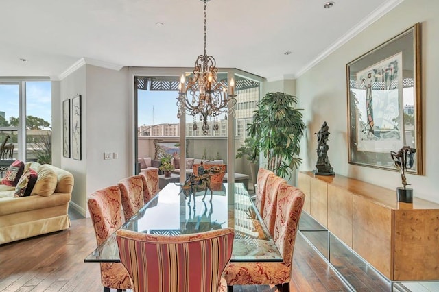 dining area featuring hardwood / wood-style flooring, crown molding, and an inviting chandelier