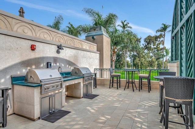 view of patio with an outdoor kitchen and a grill