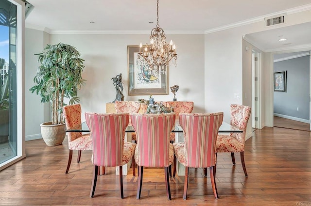 dining room with a chandelier, ornamental molding, and hardwood / wood-style floors