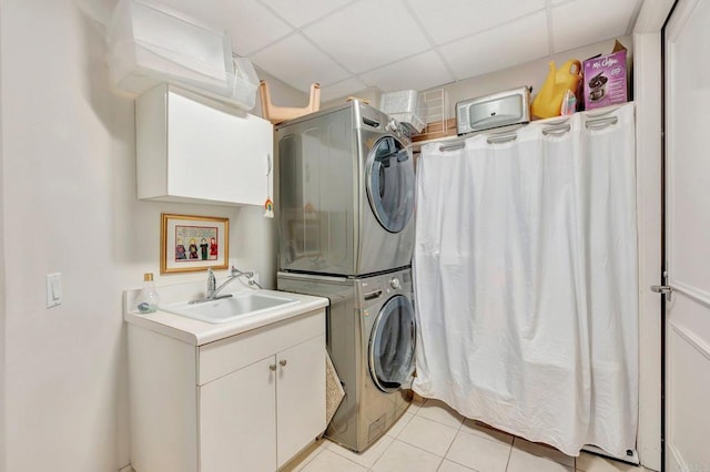 washroom featuring cabinets, stacked washer / dryer, sink, and light tile patterned flooring