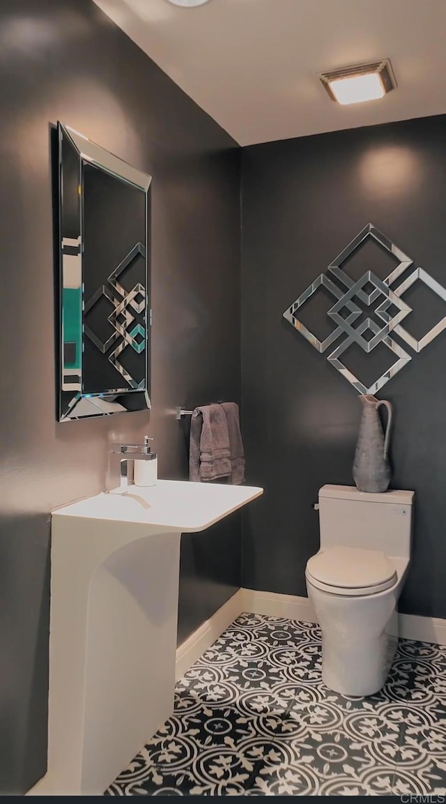 bathroom with toilet and tile patterned flooring