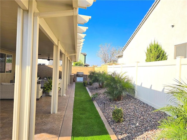 view of yard with ceiling fan and a patio area