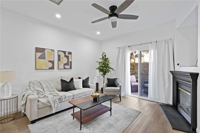 living room featuring ceiling fan and light wood-type flooring