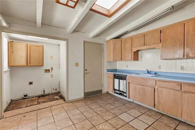 kitchen with dishwashing machine, backsplash, a sink, light countertops, and beam ceiling