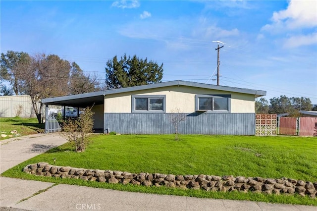 view of front facade featuring an attached carport, concrete driveway, fence, and a front yard