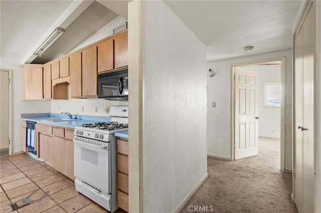 kitchen with black appliances, light brown cabinets, light countertops, and a sink