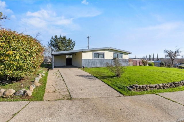 view of front facade with a front yard, concrete driveway, and an attached carport