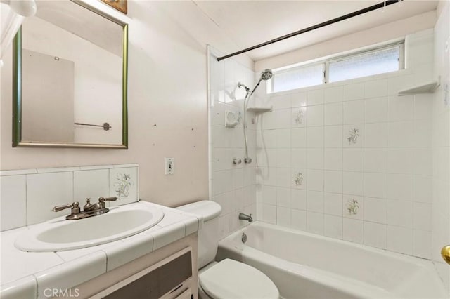 bathroom featuring toilet, washtub / shower combination, backsplash, and vanity