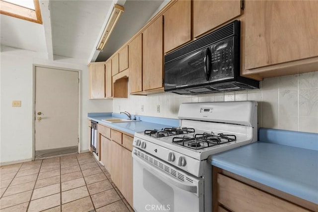 kitchen featuring black microwave, a sink, light countertops, decorative backsplash, and gas range gas stove