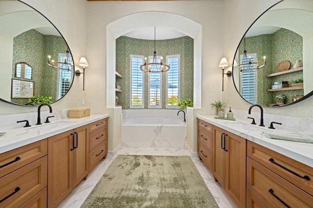 bathroom with vanity, a notable chandelier, and a relaxing tiled tub