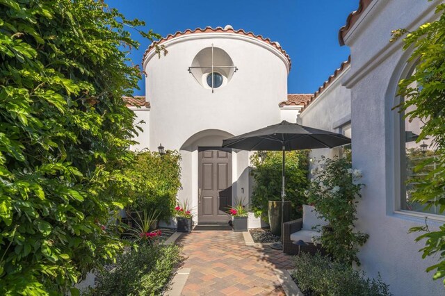 view of exterior entry with a patio area