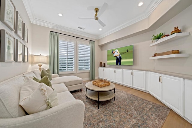 living room with ceiling fan, ornamental molding, and light hardwood / wood-style floors