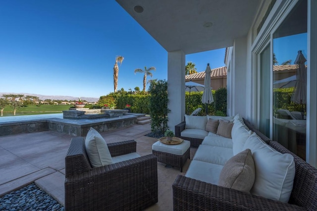 view of patio with a hot tub and a mountain view