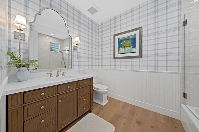 bathroom featuring a shower, hardwood / wood-style floors, toilet, and vanity