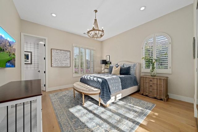 bedroom with light hardwood / wood-style flooring and an inviting chandelier