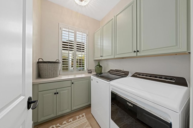 clothes washing area featuring washing machine and clothes dryer and cabinets