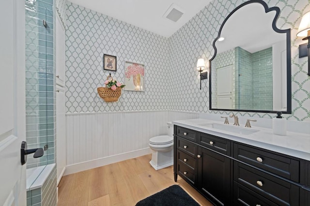 bathroom with toilet, vanity, walk in shower, and hardwood / wood-style flooring