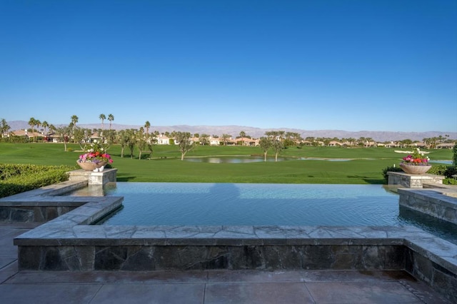 surrounding community with a water and mountain view and a lawn