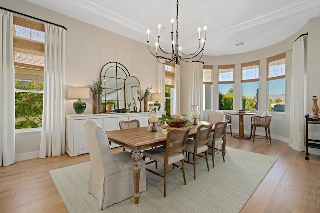 dining room with a chandelier, crown molding, and light hardwood / wood-style floors