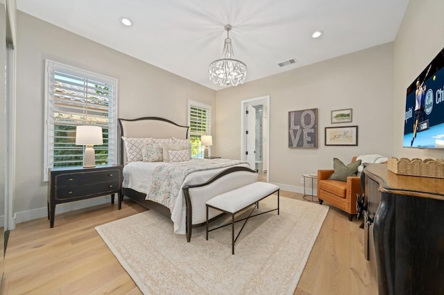 bedroom featuring light hardwood / wood-style floors and an inviting chandelier