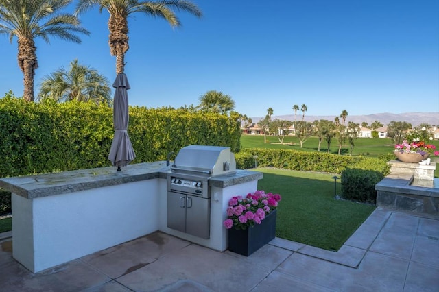 view of patio featuring a mountain view, an outdoor kitchen, and grilling area